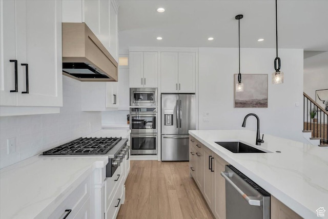 529 E 4290 S, Washington, UT 84780 - kitchen featuring stainless steel appliances, wall chimney range hood, light wood finished floors, light stone counters, and decorative light fixtures