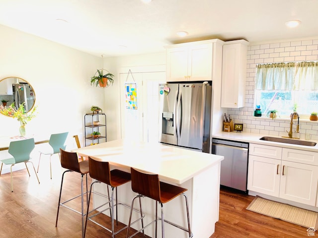 665 S 1040 E, Spanish Fork, UT 84660 - kitchen with stainless steel appliances, a kitchen breakfast bar, white cabinetry, wood finished floors, and recessed lighting