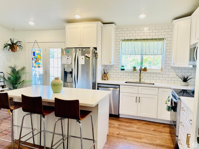 665 S 1040 E, Spanish Fork, UT 84660 - kitchen with stainless steel appliances, white cabinetry, a kitchen island, tasteful backsplash, and light countertops
