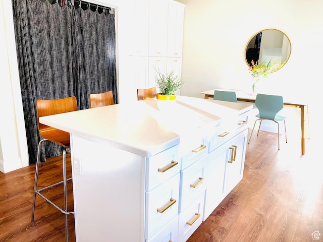 665 S 1040 E, Spanish Fork, UT 84660 - kitchen featuring a breakfast bar, light wood-style floors, a kitchen island, and white cabinets