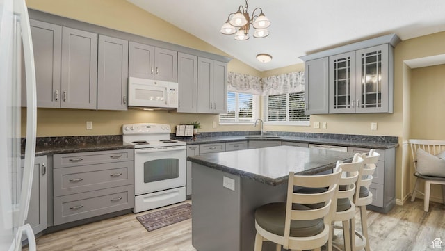 4403 W 3850 S, West Haven, UT 84401 - kitchen featuring white appliances, gray cabinets, lofted ceiling, a breakfast bar, and light wood-style flooring