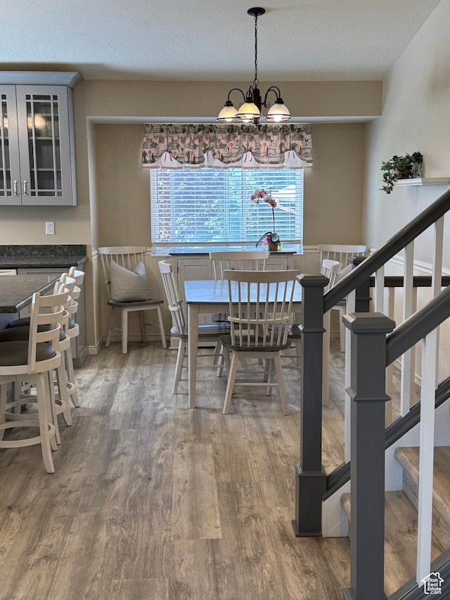 4403 W 3850 S, West Haven, UT 84401 - dining space featuring wood finished floors, stairway, a chandelier, healthy amount of natural light, and a textured ceiling