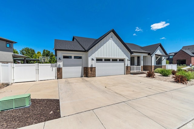 992 W Emily Francis Cir S, Jordan, UT 84095 - modern farmhouse with board and batten siding, an attached garage, brick siding, concrete driveway, and a gate