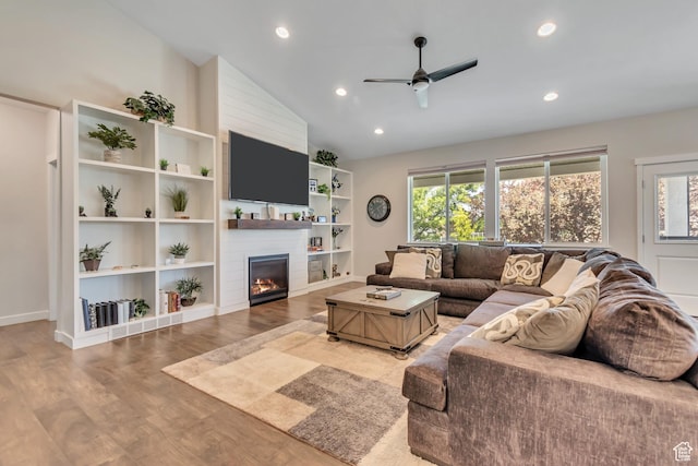 992 W Emily Francis Cir S, Jordan, UT 84095 - living area featuring vaulted ceiling, a ceiling fan, plenty of natural light, a large fireplace, and wood finished floors