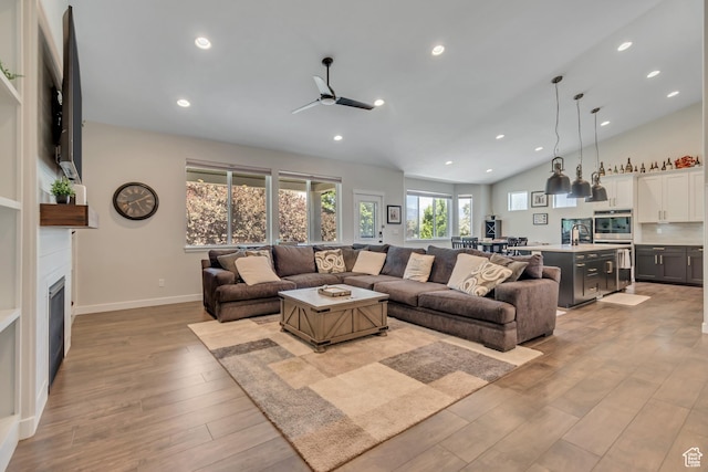 992 W Emily Francis Cir S, Jordan, UT 84095 - living room featuring light wood-style flooring, ceiling fan, a fireplace, vaulted ceiling, and recessed lighting