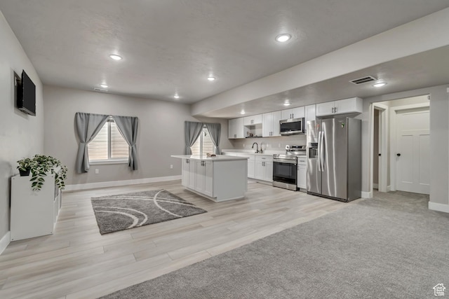 992 W Emily Francis Cir S, Jordan, UT 84095 - kitchen with appliances with stainless steel finishes, white cabinets, light countertops, recessed lighting, and a kitchen island