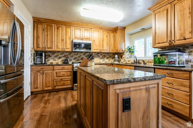11805 S Sunset Ponds Dr Unit 5, Draper, UT 84020 - kitchen with appliances with stainless steel finishes, dark wood-style floors, dark stone countertops, decorative backsplash, and a textured ceiling