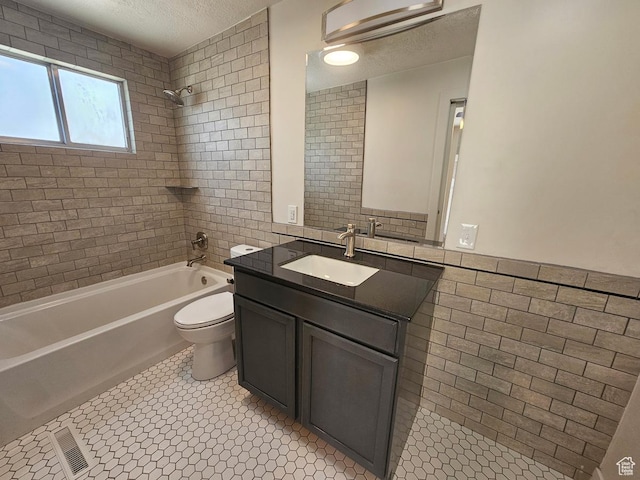 10138 S Peony Way, Sandy, UT 84094 - bathroom with a textured ceiling, tile walls, vanity, and shower / washtub combination