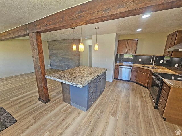 10138 S Peony Way, Sandy, UT 84094 - kitchen featuring appliances with stainless steel finishes, light wood-style flooring, pendant lighting, a center island, and light stone countertops