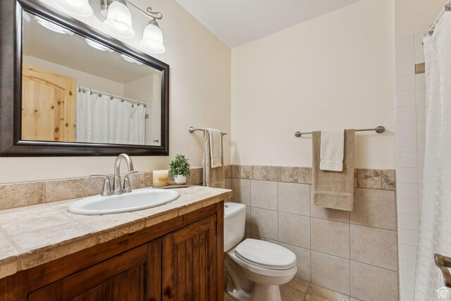 4714 S Idlewild Rd, Millcreek, UT 84124 - full bathroom featuring tile walls, vanity, a wainscoted wall, a shower with shower curtain, and tile patterned flooring