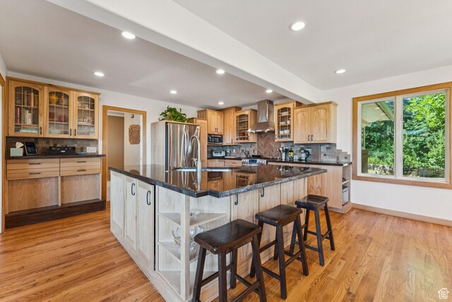 4714 S Idlewild Rd, Millcreek, UT 84124 - kitchen featuring stainless steel appliances, wall chimney range hood, backsplash, light wood finished floors, and recessed lighting