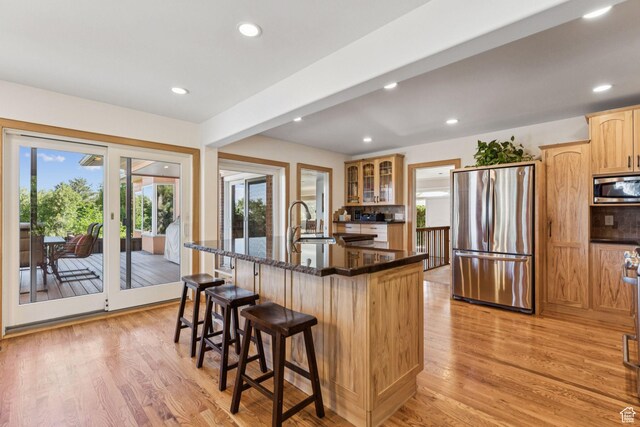 4714 S Idlewild Rd, Millcreek, UT 84124 - kitchen with stainless steel appliances, light wood finished floors, plenty of natural light, a kitchen bar, and recessed lighting