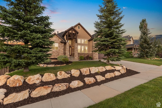 15337 S Eagle Crest Dr E, Draper, UT 84020 - english style home featuring stone siding, stucco siding, a yard, concrete driveway, and a garage