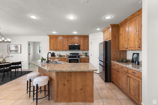 15337 S Eagle Crest Dr E, Draper, UT 84020 - kitchen with appliances with stainless steel finishes, a kitchen island with sink, light tile patterned flooring, brown cabinets, and recessed lighting