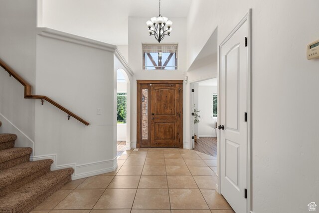 15337 S Eagle Crest Dr E, Draper, UT 84020 - foyer entrance featuring light tile patterned floors, a chandelier, stairs, and a high ceiling