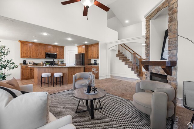 15337 S Eagle Crest Dr E, Draper, UT 84020 - living room featuring a stone fireplace, a high ceiling, recessed lighting, ceiling fan, and stairway