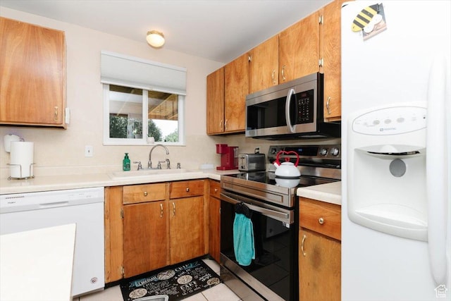 623 W 1635 N, Clinton, UT 84015 - kitchen with stainless steel appliances, brown cabinetry, light countertops, and light tile patterned floors