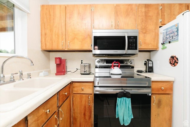 623 W 1635 N, Clinton, UT 84015 - kitchen featuring stainless steel appliances, light countertops, tile patterned flooring, and brown cabinetry