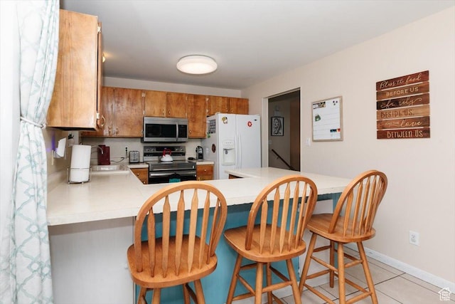 623 W 1635 N, Clinton, UT 84015 - kitchen with stainless steel microwave, electric range, white refrigerator with ice dispenser, light countertops, and brown cabinets