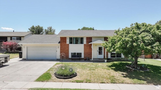 623 W 1635 N, Clinton, UT 84015 - bi-level home featuring a garage, concrete driveway, a front lawn, and brick siding