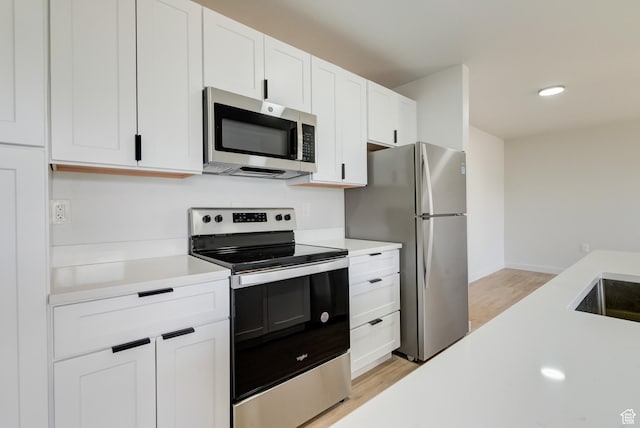 404 E 5600 S, Murray, UT 84107 - kitchen featuring stainless steel appliances, light countertops, light wood-type flooring, white cabinetry, and recessed lighting
