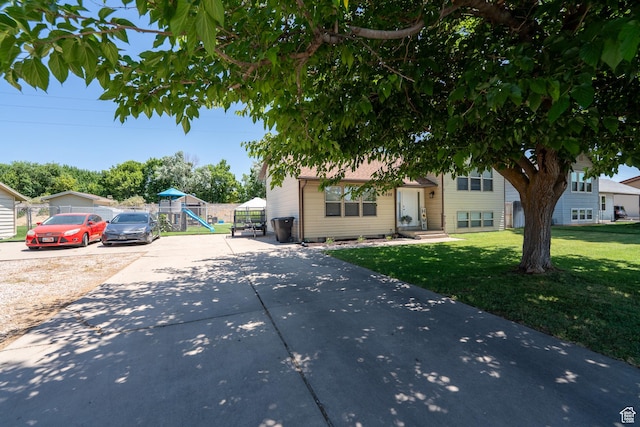 2466 N 1050 W, Clinton, UT 84015 - view of front facade featuring driveway, a front yard, and a playground