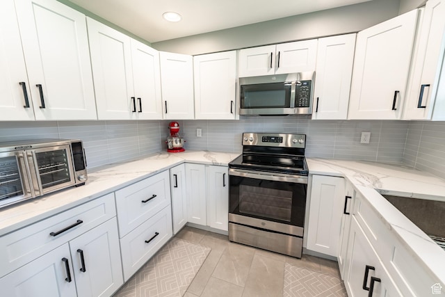 2466 N 1050 W, Clinton, UT 84015 - kitchen featuring stainless steel appliances, white cabinets, light tile patterned floors, backsplash, and recessed lighting