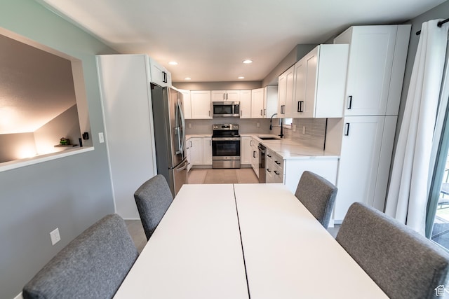 2466 N 1050 W, Clinton, UT 84015 - kitchen featuring appliances with stainless steel finishes, decorative backsplash, light countertops, white cabinetry, and recessed lighting