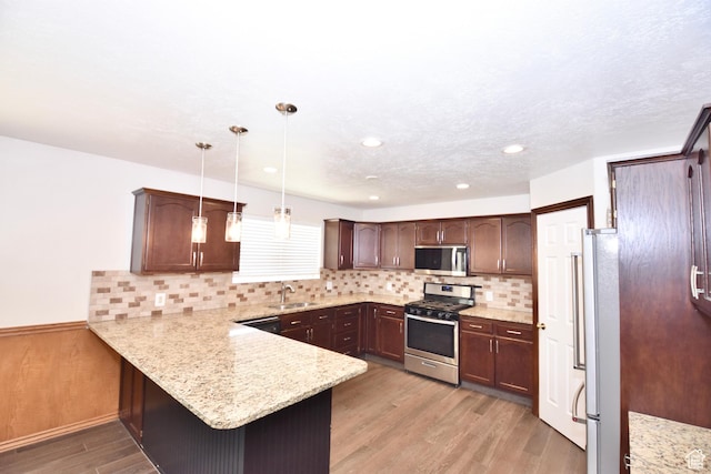 686 E 400 N, Lehi, UT 84043 - kitchen with appliances with stainless steel finishes, a peninsula, light wood finished floors, dark brown cabinets, and decorative backsplash