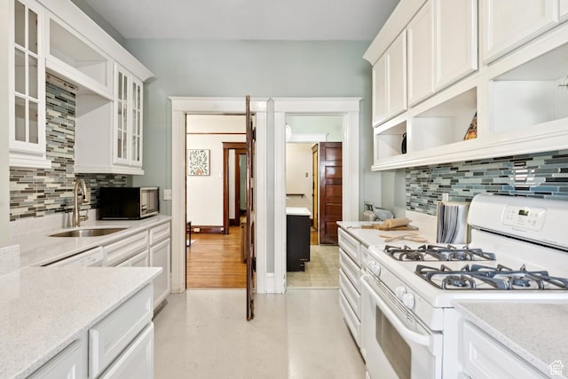 310 S 300 E Unit A2, Salt Lake City, UT 84111 - kitchen featuring white gas range, open shelves, decorative backsplash, white cabinets, and glass insert cabinets