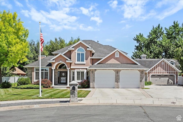 1964 N 2000 E, Layton, UT 84040 - traditional home featuring a garage, concrete driveway, stucco siding, a shingled roof, and brick siding