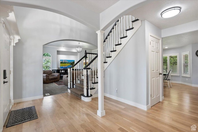 1964 N 2000 E, Layton, UT 84040 - foyer entrance with arched walkways, wood finished floors, stairway, and a textured ceiling