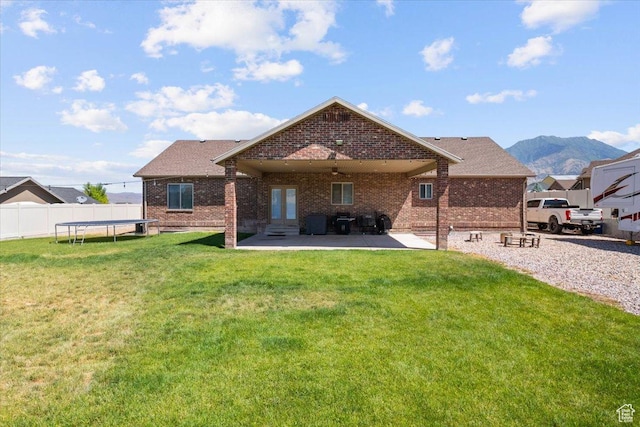 216 E 1370 S, Nephi, UT 84648 - back of house with a trampoline, brick siding, a patio, and a mountain view