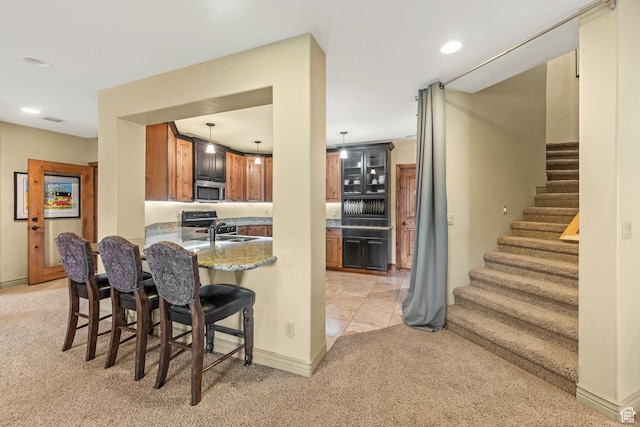364 N Tanner Ln, Midway, UT 84049 - kitchen with light carpet, stainless steel microwave, a kitchen bar, a peninsula, and range