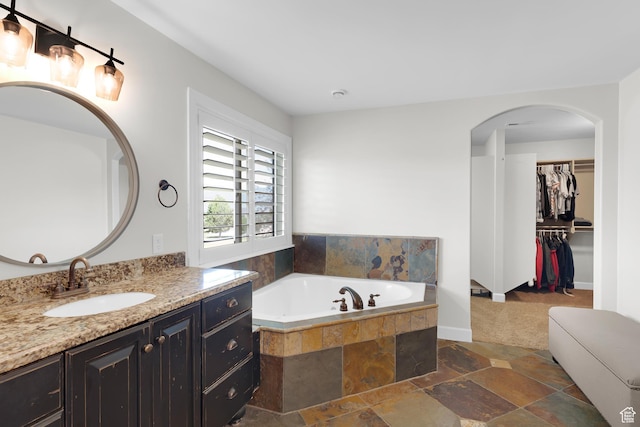 916 Ledgestone Ln, Heber City, UT 84032 - bathroom with vanity, a garden tub, stone finish floors, and a spacious closet