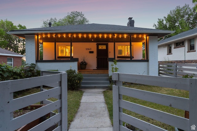 1163 E Blaine Ave, Salt Lake City, UT 84105 - view of front of property with brick siding, a chimney, covered porch, and roof with shingles