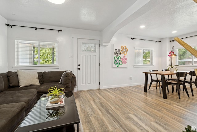 1163 E Blaine Ave, Salt Lake City, UT 84105 - living room featuring light wood-type flooring, a textured ceiling, recessed lighting, and arched walkways