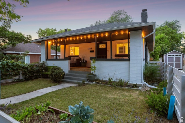 1163 E Blaine Ave, Salt Lake City, UT 84105 - view of front of property featuring brick siding, a chimney, a storage unit, and covered porch