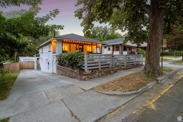 1163 E Blaine Ave, Salt Lake City, UT 84105 - view of front facade featuring a fenced front yard, driveway, and covered porch