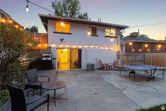 1163 E Blaine Ave, Salt Lake City, UT 84105 - back of property at dusk featuring a patio area, a fenced backyard, and brick siding