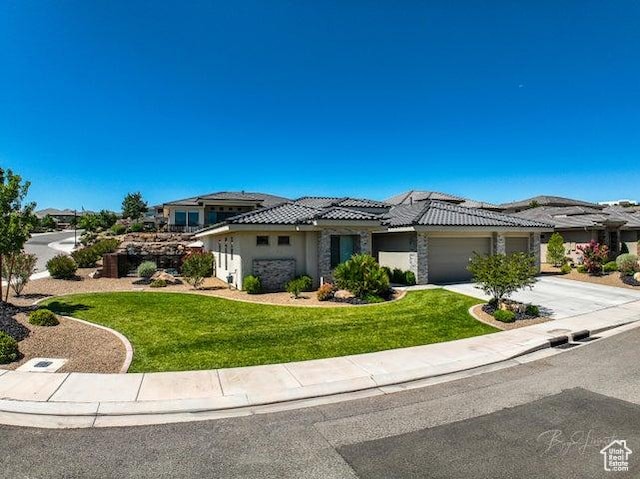2893 W Nemi Ln, St George, UT 84770 - view of front facade with a garage, a front yard, driveway, a tiled roof, and stucco siding