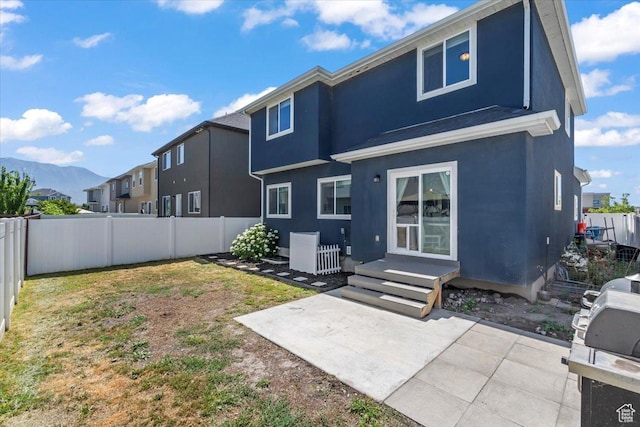 64 W 470 N, Vineyard, UT 84059 - rear view of house featuring stucco siding, a fenced backyard, a patio area, and a mountain view