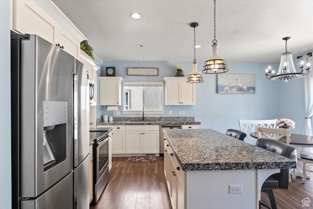 64 W 470 N, Vineyard, UT 84059 - kitchen featuring appliances with stainless steel finishes, dark wood-style flooring, a breakfast bar, a kitchen island, and recessed lighting