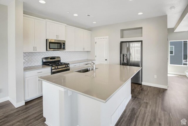 75 N Rio Grand Ave, Farmington, UT 84025 - kitchen with stainless steel appliances, a kitchen island with sink, dark wood finished floors, decorative backsplash, and white cabinetry
