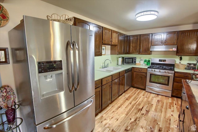 1184 16th St Unit B, Ogden, UT 84404 - kitchen featuring appliances with stainless steel finishes, under cabinet range hood, light wood-style floors, and light countertops