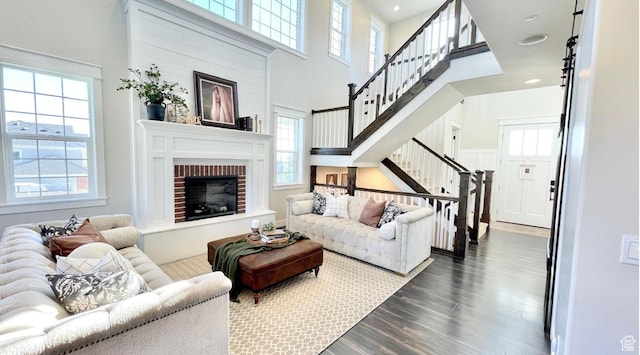 14312 S Herriman View Way, Herriman, UT 84096 - living room with healthy amount of natural light, stairs, dark wood-type flooring, a brick fireplace, and a towering ceiling