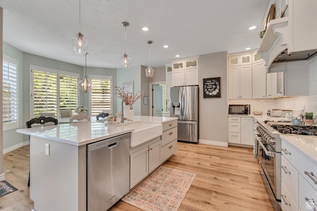 3065 W Current Creek Dr, South Jordan, UT 84095 - kitchen with appliances with stainless steel finishes, recessed lighting, a kitchen island with sink, pendant lighting, and light wood-style floors