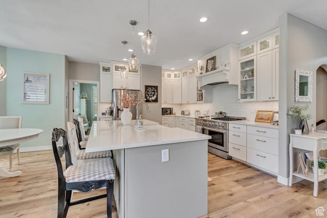 3065 W Current Creek Dr, South Jordan, UT 84095 - kitchen with stainless steel appliances, light wood-style flooring, a kitchen breakfast bar, white cabinets, and recessed lighting