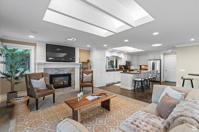 8022 S Deer Creek Rd E, Cottonwood Heights, UT 84121 - living room featuring a skylight, crown molding, a fireplace with flush hearth, recessed lighting, and wood finished floors