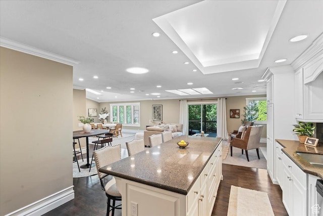 8022 S Deer Creek Rd E, Cottonwood Heights, UT 84121 - kitchen with a kitchen bar, dark wood-type flooring, a center island, recessed lighting, and white cabinetry